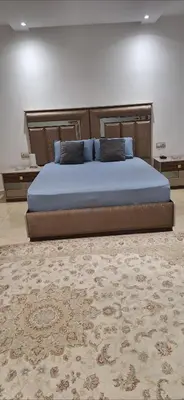 a large bed in a bedroom with a rug at Étage d'une prestigieuse villa in Rabat