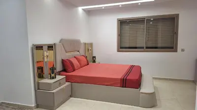 a bedroom with a bed with red sheets and a window at Étage d'une prestigieuse villa in Rabat