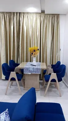 a dining room with blue chairs and a table with a vase of flowers at Studio Chefchaoun in Deroua