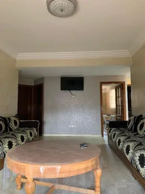 a living room with a couch and a coffee table at RESIDENCE PLAGE MANESMANe in Mohammedia