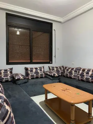 a living room with a couch and a table at RESIDENCE PLAGE MANESMANe in Mohammedia