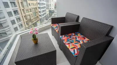 two wicker chairs and a table on a balcony at City Chic stade&centre Princesse in Casablanca