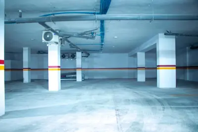 an empty parking lot with white columns and a camera at City Chic stade&centre Princesse in Casablanca