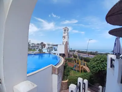 a view from a balcony with a pool and a lighthouse at Cosy Studio Sea View in Casablanca in Tamaris