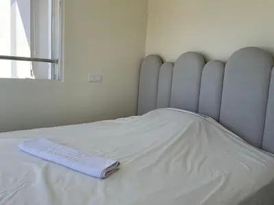 a white bed with a blanket on top of it at Cosy Studio Sea View in Casablanca in Tamaris