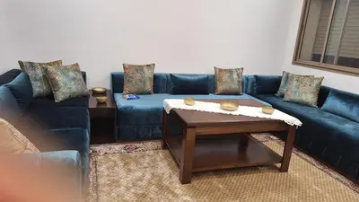a living room with a blue couch and a table at Luxe Suite au sein d'une villa in Rabat