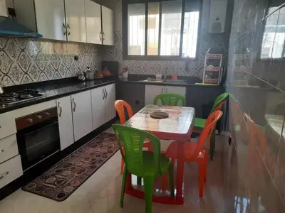 a kitchen with a table and chairs and a stove at Bouznika mandarona in Bouznika