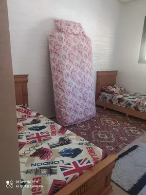 a bedroom with two twin beds and a large pillow at Bouznika mandarona in Bouznika