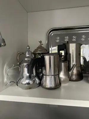 a row of silver tea pots and pans on a shelf at Le LOFT in Casablanca
