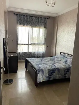 a bedroom with a bed and a large window at Skhirat Beach Appartement in Skhirat