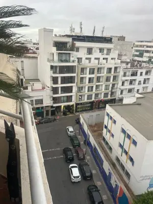 a city street with cars parked in front of buildings at twins in Casablanca