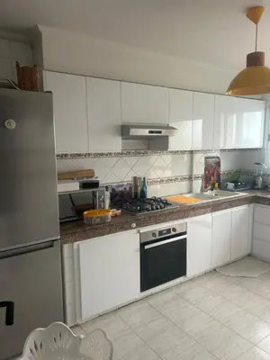 a kitchen with white cabinets and a stove top oven at twins in Casablanca