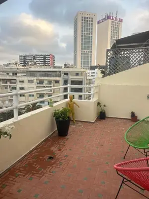 a teddy bear on a balcony with a city skyline at twins in Casablanca