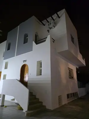 a white building with a staircase in front of it at Seaside Artist's Villa in Temara