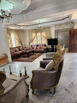 a large living room with couches and a glass table at Villa mouna in Mohammedia
