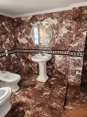a bathroom with two toilets and a sink and a mirror at Villa mouna in Mohammedia