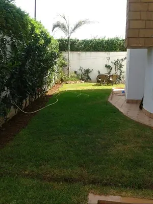 a backyard with a lawn with a hose at Villa mouna in Mohammedia
