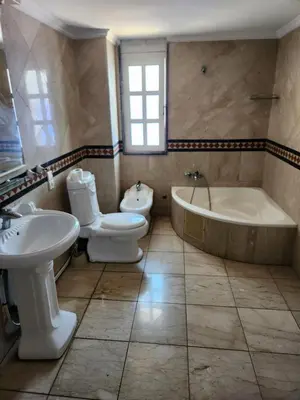 a bathroom with a tub and a toilet and a sink at Villa mouna in Mohammedia