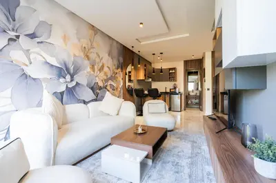 a living room with a white couch and flowers on the wall at Résidence Cerezo in Maarif