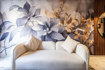 a couch in a room with a floral wall at Résidence Cerezo in Maarif