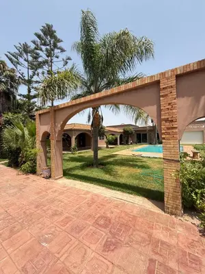 a brick bridge over a yard with a pool at Chic home with a private pool in Dar Mouddene