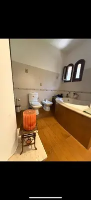 a bathroom with a toilet and a tub and a sink at Chic home with a private pool in Dar Mouddene