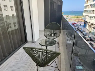 a balcony with two chairs and a table on a building at Stylish Apartment with a seaview 9 in Casablanca