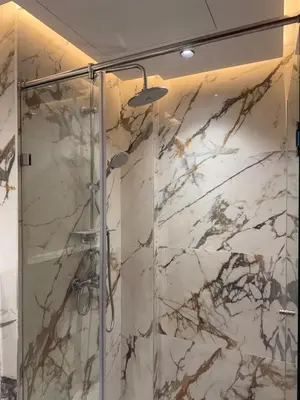 a bathroom with a shower with marble walls at Stylish Apartment with a seaview 9 in Casablanca