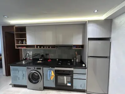 a kitchen with a stove and a refrigerator and a washer at Studio au Parc Mohammedia in Mohammedia