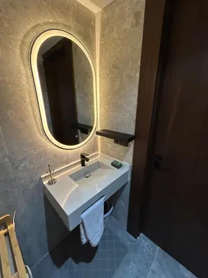 a bathroom with a white sink and a mirror at Studio au Parc Mohammedia in Mohammedia