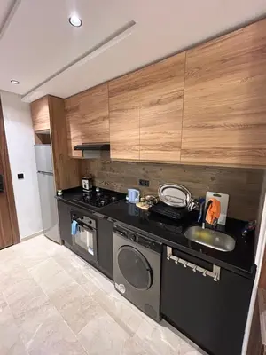a kitchen with a sink and a washing machine at Studio au Parc Mohammedia in Mohammedia