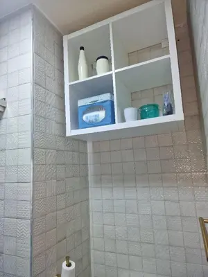 a bathroom with a white cabinet with dishes on it at Votre Appartement neuf meublé vous attend in Skhirat