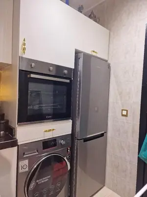 a kitchen with a washing machine and a microwave at Votre Appartement neuf meublé vous attend in Skhirat