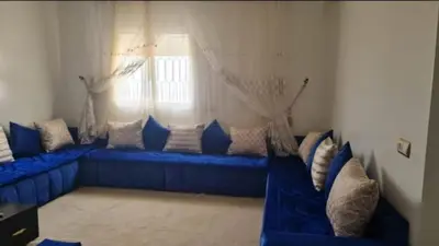 a blue couch in a living room with a window at Votre Appartement neuf meublé vous attend in Skhirat