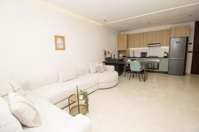 a living room with a white couch and a kitchen at Luxurious studio Great location in Casablanca