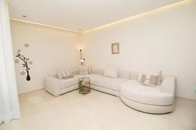 a white living room with a couch and a table at Luxurious studio Great location in Casablanca