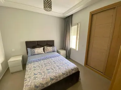 a bedroom with a bed and a window and a door at Ola Blanca in Dar Hamida