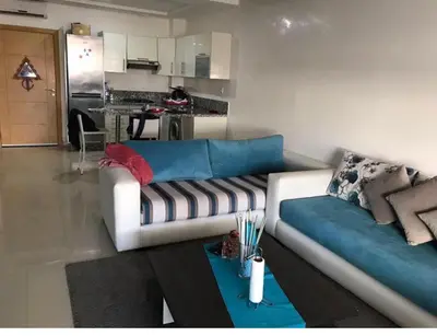 a living room with a couch and a kitchen at Ola Blanca in Dar Hamida