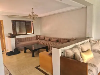 a living room with a couch and a table at Villa pied dans l'eau in Sidi Rahal