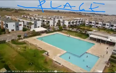 a large apartment complex with a large swimming pool at Villa pied dans l'eau in Sidi Rahal