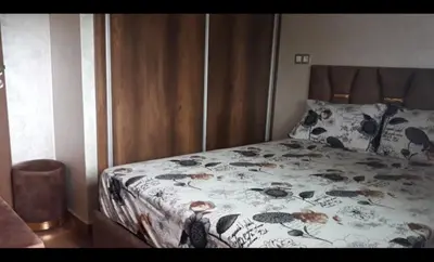 a bedroom with a bed with a floral comforter at Blue Beach sidi rahal in Sidi Rahal
