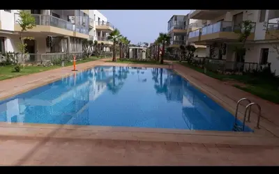 a large swimming pool in front of some apartment buildings at Blue Beach sidi rahal in Sidi Rahal