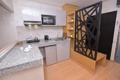 a kitchen with white cabinets and a counter top at Le 135 appart hotel in Casablanca