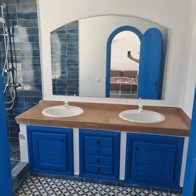 a bathroom with two sinks and a mirror at Private villa with pool in Bouznika