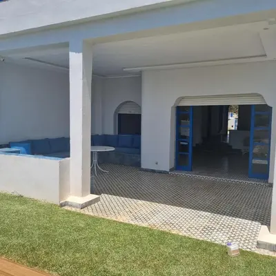 a view of a patio with a table under a building at Private villa with pool in Bouznika