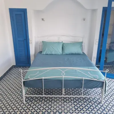 a bed in a room with a blue door at Private villa with pool in Bouznika