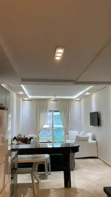 a living room with a table and a couch at Appartement à Ritaj Beach in Casablanca