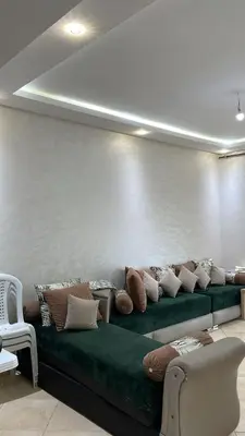 a room with a green couch with pillows on it at Appartement à Ritaj Beach in Casablanca