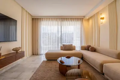 a living room with a couch and a table at Le yacht apartment II Oceanfront residence 2 BR 2 BA in Casablanca