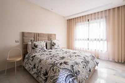 a bedroom with a large bed with a large window at Le yacht palace beachfront residence 2 BR 2 BA in Casablanca